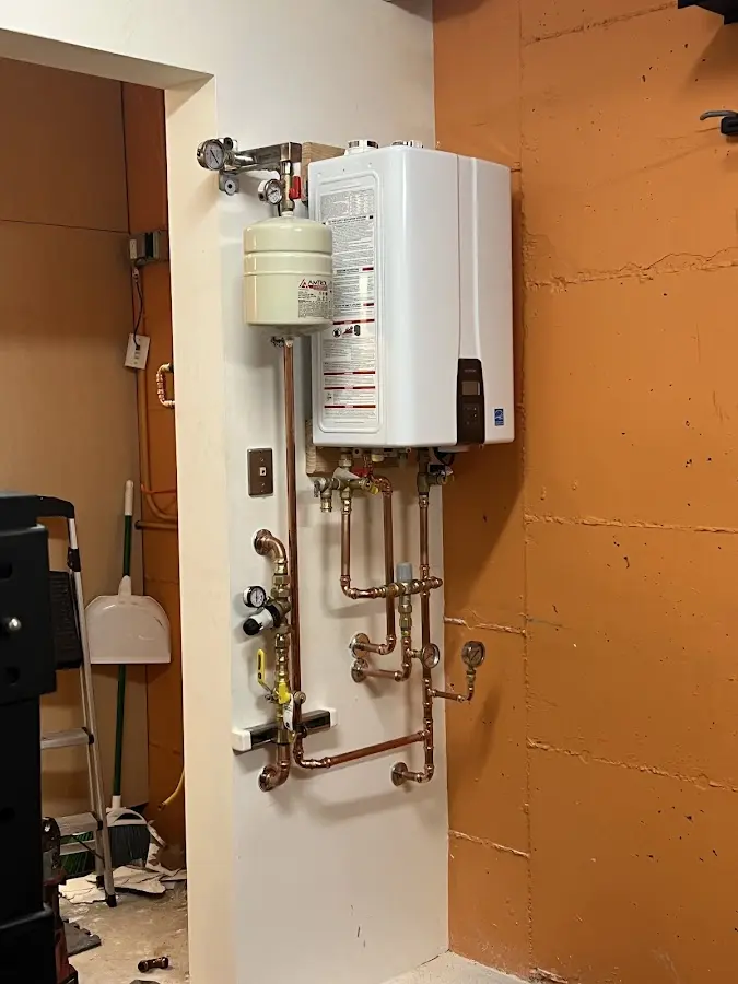 Plumbing technician inspecting water heater connections in Conley